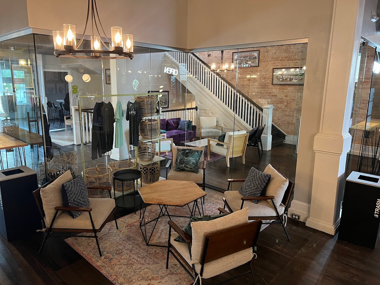 Cozy lounge area with armchairs, staircase, and warm lighting at Flourish Taproom